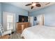 Cozy main bedroom features light-blue walls, hardwood floors, a dresser, and a glass patio door at 129 Treviso Ct, North Venice, FL 34275