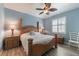 Comfortable main bedroom with light-blue walls, hardwood floors, and an elegant wooden bed frame at 129 Treviso Ct, North Venice, FL 34275