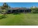 Lush lawn and landscaping highlight the back of this home, including the screened-in pool at 13551 Carnoustie Cir, Dade City, FL 33525
