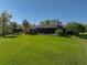 A well-manicured lawn surrounds this home's rear exterior with screened-in patio at 13551 Carnoustie Cir, Dade City, FL 33525