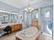 Bathroom featuring a soaking tub, dual vanities and dual walk-in shower stalls at 13551 Carnoustie Cir, Dade City, FL 33525