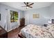 Bedroom featuring a large window with hardwood flooring, a ceiling fan, and furnishings at 13551 Carnoustie Cir, Dade City, FL 33525
