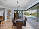 Dining room with pendant lighting, a table for four, and access to a screened-in patio with a pool view at 13551 Carnoustie Cir, Dade City, FL 33525