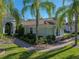 Charming home exterior with a brick walkway, lush greenery, and manicured landscaping at 13551 Carnoustie Cir, Dade City, FL 33525