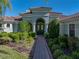 Inviting front entrance with a brick walkway, lush greenery, and well-maintained landscaping at 13551 Carnoustie Cir, Dade City, FL 33525