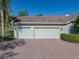 The three-car garage boasts an expansive paver driveway and verdant landscaping at 13551 Carnoustie Cir, Dade City, FL 33525