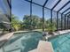 The screened-in spa tub has a waterfall feature and is set in the corner of the pool area at 13551 Carnoustie Cir, Dade City, FL 33525