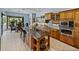 Large island anchors this well-equipped kitchen with wooden cabinets, stainless steel appliances, and tile floors at 13551 Carnoustie Cir, Dade City, FL 33525