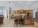 Spacious kitchen offers a large island with bar seating, wooden cabinetry, granite counters, and stainless steel appliances at 13551 Carnoustie Cir, Dade City, FL 33525