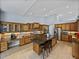Gourmet kitchen with wood cabinets, granite countertops, stainless steel appliances, and a center island with bar stools at 13551 Carnoustie Cir, Dade City, FL 33525