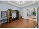 Living room with hardwood floors, built-in shelving, and open access to another room at 13551 Carnoustie Cir, Dade City, FL 33525