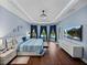 Main bedroom with tray ceiling, wood floors, and view of the pool at 13551 Carnoustie Cir, Dade City, FL 33525