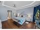 Main bedroom featuring hardwood floors, tray ceilings, and access to closets at 13551 Carnoustie Cir, Dade City, FL 33525