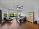 Office boasts hardwood floors, a large window offering garden views, and a modern glass-top desk at 13551 Carnoustie Cir, Dade City, FL 33525