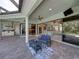 Expansive outdoor patio with comfortable seating, kitchen, and seamless indoor/outdoor flow at 13551 Carnoustie Cir, Dade City, FL 33525
