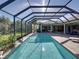 The screened-in pool is surrounded by brick pavers and has a waterfall feature at 13551 Carnoustie Cir, Dade City, FL 33525