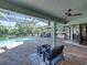 Expansive screened pool area with ample seating, outdoor kitchen, and serene backyard views at 13551 Carnoustie Cir, Dade City, FL 33525