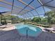 Stunning screened pool with a spa, offering views of the serene backyard and surrounding landscape at 13551 Carnoustie Cir, Dade City, FL 33525