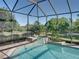 Tranquil screened pool and spa with views of the lush backyard, creating a private outdoor sanctuary at 13551 Carnoustie Cir, Dade City, FL 33525