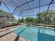 Beautiful screened pool and spa offering serene views of the backyard, creating a private oasis at 13551 Carnoustie Cir, Dade City, FL 33525