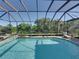 Inviting screened pool with clear water and lush landscaping, offering a perfect oasis for relaxation at 13551 Carnoustie Cir, Dade City, FL 33525