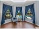 Sitting area with great pool views from large windows with stylish blue curtains at 13551 Carnoustie Cir, Dade City, FL 33525