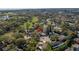 Aerial view of a home with surrounding properties and trees, marked with a red arrow at 13982 Whisperwood Dr, Clearwater, FL 33762