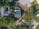 Aerial view of a home with a backyard pool, surrounded by trees and a red property line at 13982 Whisperwood Dr, Clearwater, FL 33762
