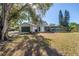 Spacious backyard with a screened-in pool area, garage, and ample green space at 13982 Whisperwood Dr, Clearwater, FL 33762