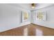 Empty bedroom with hardwood floors, two windows and ceiling fan at 13982 Whisperwood Dr, Clearwater, FL 33762