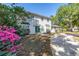 Charming two-story home features a white brick exterior, green front door, and beautiful landscaping at 13982 Whisperwood Dr, Clearwater, FL 33762