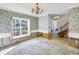 Spacious living room featuring bright window, chandelier and partial flooring at 13982 Whisperwood Dr, Clearwater, FL 33762