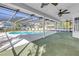 Inviting screened-in pool with a covered patio featuring ceiling fans, perfect for outdoor relaxation at 13982 Whisperwood Dr, Clearwater, FL 33762