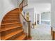Elegant curved wooden staircase and bright open floor plan create a welcoming atmosphere at 13982 Whisperwood Dr, Clearwater, FL 33762