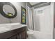 Bright bathroom features sleek vanity, round mirror, and tiled shower-tub combo at 14123 Barrington Stowers Dr, Lithia, FL 33547