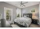 Well-lit bedroom with gray walls, a ceiling fan, and access to a balcony at 14123 Barrington Stowers Dr, Lithia, FL 33547