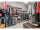 Walk-in closet with custom shelving, a hanging rod, and a comfortable ottoman at 14123 Barrington Stowers Dr, Lithia, FL 33547
