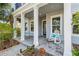 Cozy front porch with rocking chairs, columns, and neatly arranged landscaping at 14123 Barrington Stowers Dr, Lithia, FL 33547