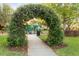 Beautiful park entrance featuring lush greenery and flowers leading to a colorful playground for children to enjoy at 14123 Barrington Stowers Dr, Lithia, FL 33547
