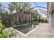 Screened pool area with spa and lush landscaping, provides a relaxing outdoor oasis for leisure and entertaining at 14123 Barrington Stowers Dr, Lithia, FL 33547