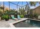 Relaxing screened pool area with two lounge chairs, tile flooring, tropical plants, and beautiful natural light at 14123 Barrington Stowers Dr, Lithia, FL 33547