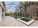 Screened pool with spa, patio, and lush landscaping offering a tranquil outdoor living space for relaxation and entertainment at 14123 Barrington Stowers Dr, Lithia, FL 33547