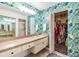 Leafy wallpaper makes this bathroom pop, complete with closet, shower and long countertop at 1837 Lake Cypress Dr # 504, Safety Harbor, FL 34695