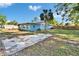 View of the backyard featuring a concrete slab, lush greenery, and a well-maintained lawn at 2035 Ronald Cir, Seffner, FL 33584