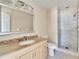 Updated bathroom features walk-in shower, modern vanity with granite countertop, and neutral color palette at 2035 Ronald Cir, Seffner, FL 33584