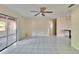 Spacious living area featuring tile floors, a ceiling fan, and access to the kitchen and sunroom at 2035 Ronald Cir, Seffner, FL 33584