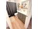 Modern bathroom with a gray vanity, decorative mirror, and a shower curtain at 2121 Beecher Rd, Clearwater, FL 33763