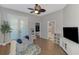 Bright, airy living room featuring tiled floor, ceiling fan, and sitting chairs with decorative rug at 218 Pesaro Dr, North Venice, FL 34275