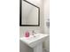 Close up of a minimalist bathroom with a pedestal sink, square mirror, and modern fixtures at 2570 12Th N Pl, St Petersburg, FL 33713