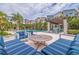 A serene pool area with lounge seating, a covered pergola, and palm trees under a partly cloudy sky for relaxation at 2570 12Th N Pl, St Petersburg, FL 33713
